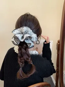 Chouchou à imprimé fleuri avec bordure en dentelle porté sur une coiffure tressée