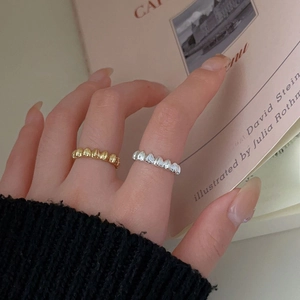 Detail of 925 sterling silver heart rings in gold and silver finish on a book