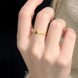 Bamboo style gold ring with a green gemstone set in an open-end design for women