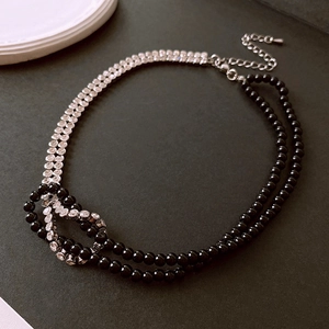 Detail of double-layer choker featuring black beads, pavé rhinestones, and silver chain