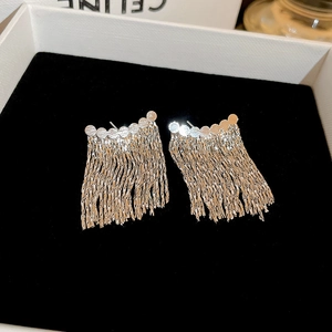 Close-up of elegant silver tassel earrings with sequin accents on black velvet background