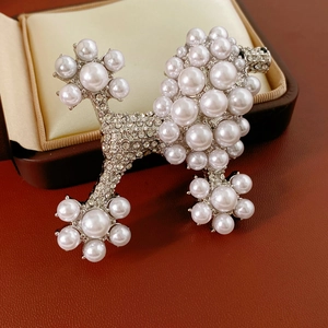 Detailed view of a vintage poodle brooch with white pearls and sparkling rhinestones