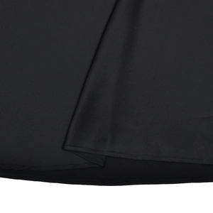Gros plan sur l'ourlet superposé et la texture du tissu de cette robe noire moulante