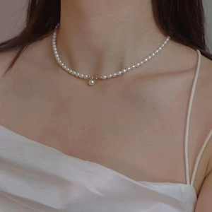 Elegant vintage freshwater pearl necklace with gold clasp on model for French luxury style