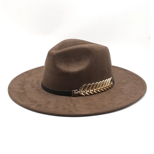 Detail of a brown fedora hat with a black leather band and a golden leaf metal buckle accessory
