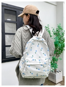 Detailed back view of a white canvas floral backpack with blue tulip patterns