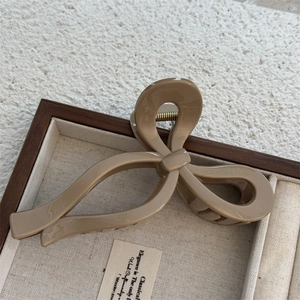 Detail of khaki brown bow hair claw clip with 'Only Belong To You' text on jewelry tray