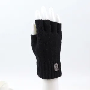Detail of black fingerless knit gloves with ribbed wrist cuff and deer head fabric patch