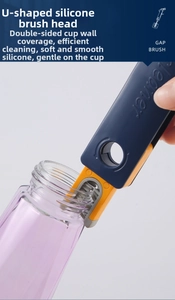 Close-up of flexible U-shaped silicone brush head cleaning the rim of a glass cup
