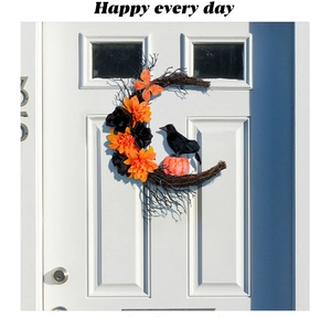 Gros plan d'une couronne de lune d'Halloween avec corbeau noir et citrouille lumineuse sur porte
