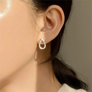 Minimalist 925 sterling silver knot stud earrings worn on model for a chic look