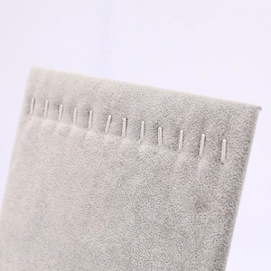 Macro view of grey velvet jewelry stand with hooks for necklaces and pendants