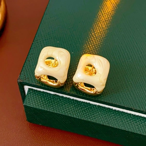Macro detail of French vintage square enamel hoop earrings with gold metal accents