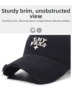 Close-up of a distressed black baseball cap with white T.NY FBXS embroidery and star detail