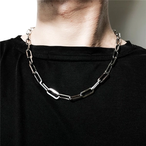Dettaglio di una collana a catena spessa in titanio argento indossata da un modello uomo