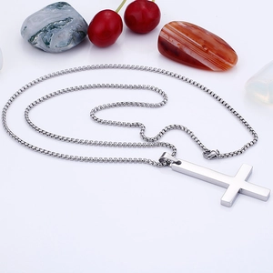Polished stainless steel cross pendant on silver box chain over white background
