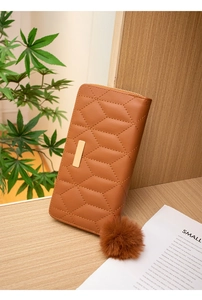 Detail of brown PU leather wallet with diamond quilting and decorative gold metal bar