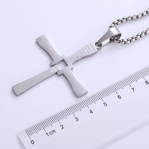 Detailed view of silver stainless steel cross pendant size measurement with a ruler