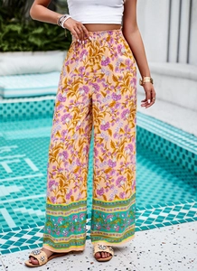 Détail du pantalon large à imprimé floral bohème en couleur abricot et violet
