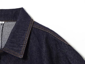 Detail view of dark blue denim jacket neckline with size M tag and contrast stitching