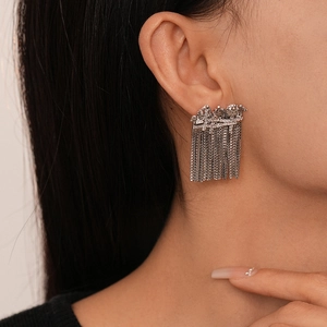 Detail shot of silver fringe earrings with cubic zirconia and long chain tassels