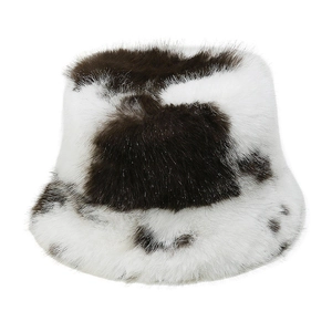 Close-up of the fluffy faux fur texture and black and white cow print on the bucket hat