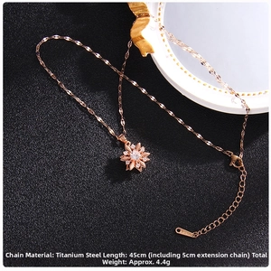 Close-up of rose gold rotating clover pendant with zircon insets on titanium steel chain