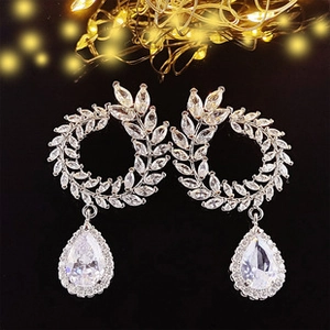 Macro detail of silver leaf earrings with AAA zircon drop pendants on black background