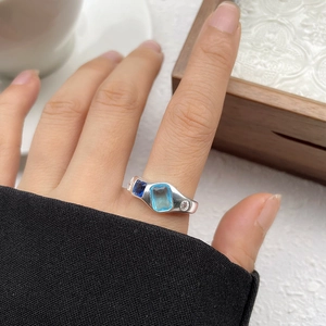 Detail of S925 silver ring with tiered blue gemstones and organic fluid line design