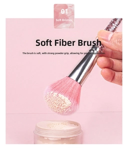 Close-up of pink soft fiber brush head applying loose powder on skin texture