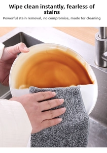 Absorbent charcoal fiber cloth wiping oil stains off white plate in kitchen sink