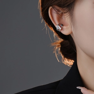 Detailed view of vintage silver snake ear cuff with black zircon on model's ear