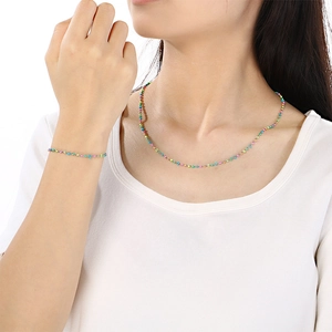 Détail des perles colorées sur l'ensemble collier et bracelet porté par un mannequin