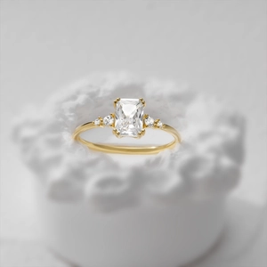 Detailed macro shot of rectangular radiant cut diamond ring on artistic white stone base