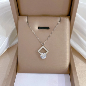Macro shot of a square geometric pendant with zircon in a jewelry box on white fabric