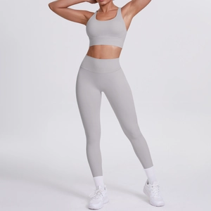 Détail d'un ensemble de yoga gris clair avec brassière croisée et legging taille haute
