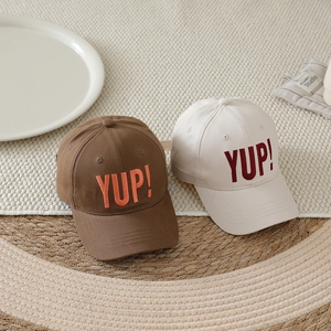 Kinder-Baseballcap mit YUP!-Stickerei in Braun und Creme im Studio-Hintergrund