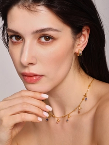 Detail of French vintage gold earrings with colored stones and a gold bird necklace