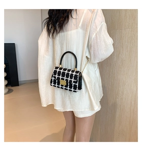 Détail du sac en tweed à carreaux avec chaîne dorée et fermoir sur une tenue blanche