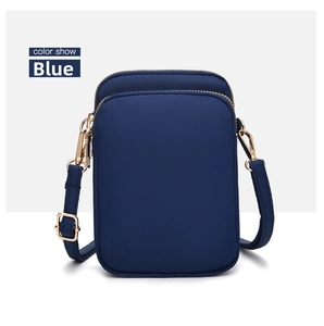 Detail of blue crossbody phone bag with double zippers and golden metal hardware