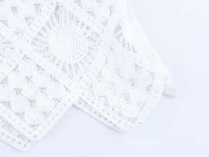Close-up of elegant white hollow lace fabric with circular floral patterns and knit texture