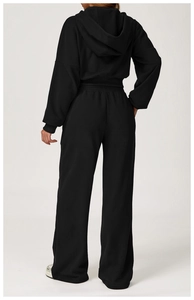Rear view of black hooded sweatshirt and high-waisted wide-leg sports pants set