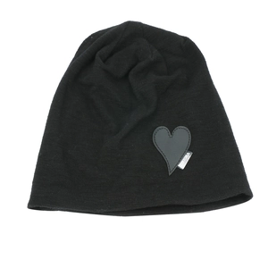 Detail of black knit beanie featuring a heart-shaped patch with PRISMA woven label