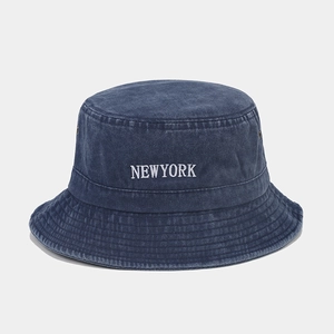 Detailed shot of dark blue washed denim bucket hat with white New York embroidery