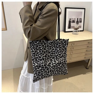 Leopard print canvas tote bag shown on model in a stylish indoor setting for daily commute
