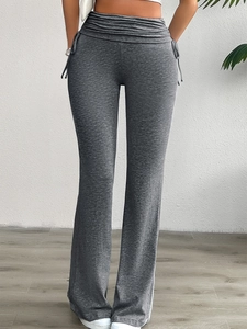 Détail du legging évasé à taille haute avec lacets et design froncé sur le côté