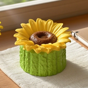 Detailed close-up of a sunflower resin ornament with vibrant yellow petals and green base