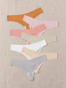Flat lay of 7-pack seamless sports thongs in various soft pastel colors for fitness