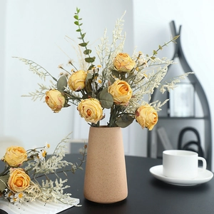 Retro dried rose bouquet with eucalyptus in beige ceramic vase for home table decor