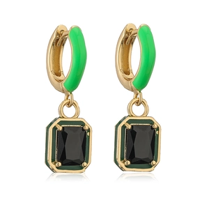Detailed view of square green enamel earrings with black gemstone in gold setting